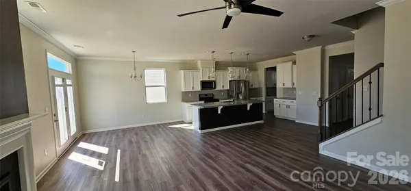 a kitchen with stainless steel appliances kitchen island wooden floors granite counter tops and window