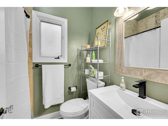 a bathroom with a sink a toilet and mirror