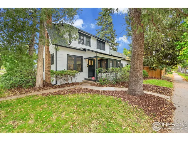 a view of a house with a yard and potted plants
