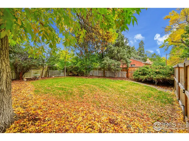 a view of a yard with yellow house