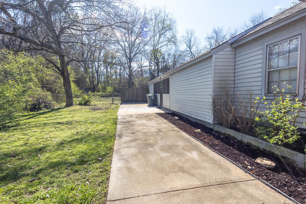 456 Gerald Road Memphis, TN 38122 - Photo 3 of 25 a backyard of a house with large trees and a lots of plant in front of it