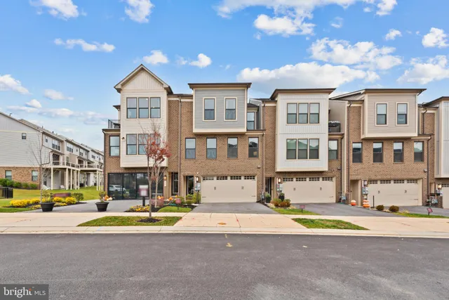 a view of a white building with a swimming pool and a yard