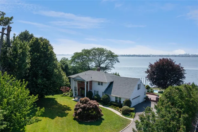 a view of a house with garden and a tree