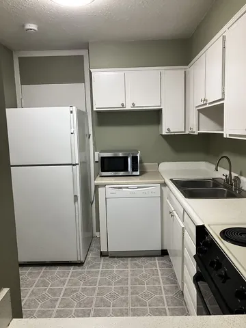 a utility room with cabinets washer and dryer