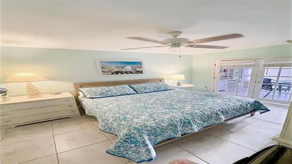 a bedroom with a large bed and a chandelier fan