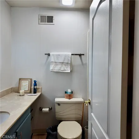 a bathroom with a granite countertop toilet sink and mirror