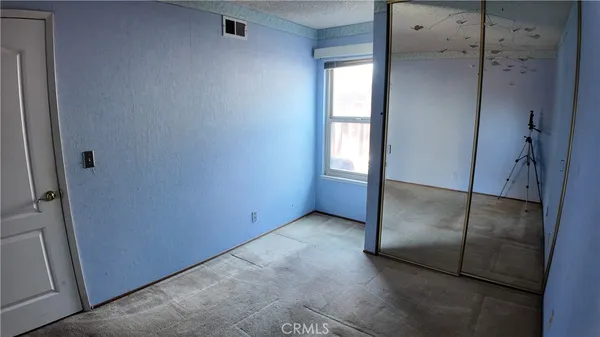an empty room with windows and closet