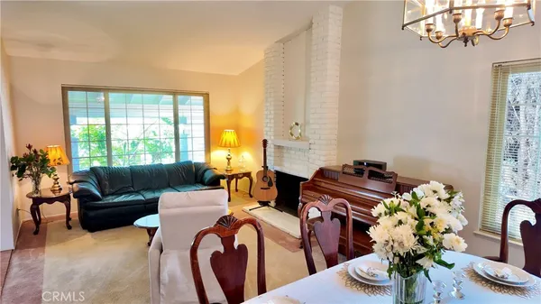 a living room with fireplace furniture and a potted plant