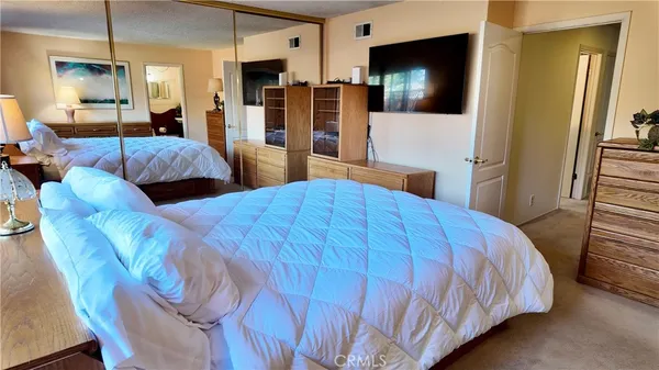 a bedroom with a bed a mirror and dresser