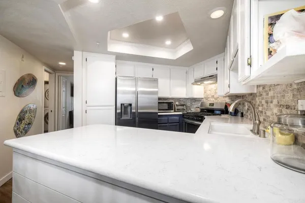 a kitchen with stainless steel appliances a refrigerator sink and stove
