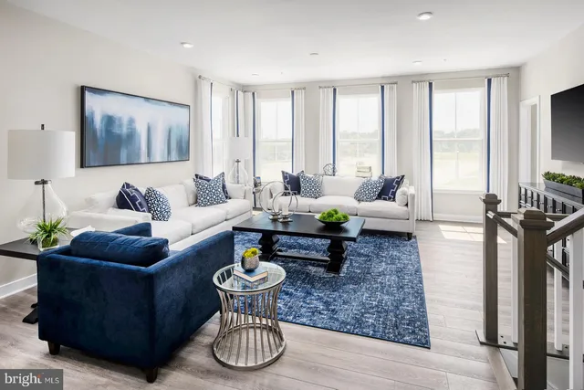 a living room with furniture couches and a large window