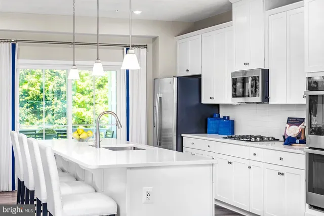 a kitchen with stainless steel appliances a white cabinets and a window