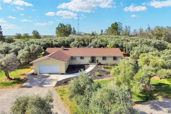 an aerial view of a house with yard and green space