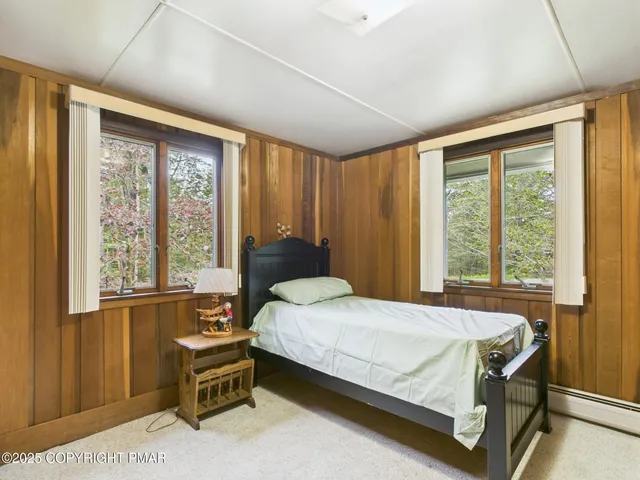 a bedroom with a bed chair and a window