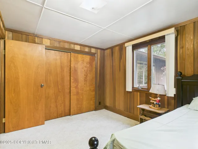 a bedroom with a bed and a large window