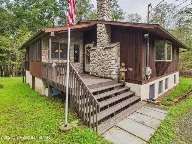 a view of a house with a yard and deck