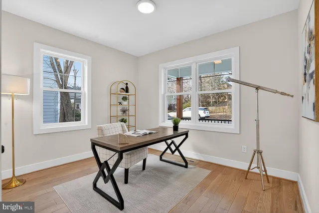 a view of a workspace with furniture and a window