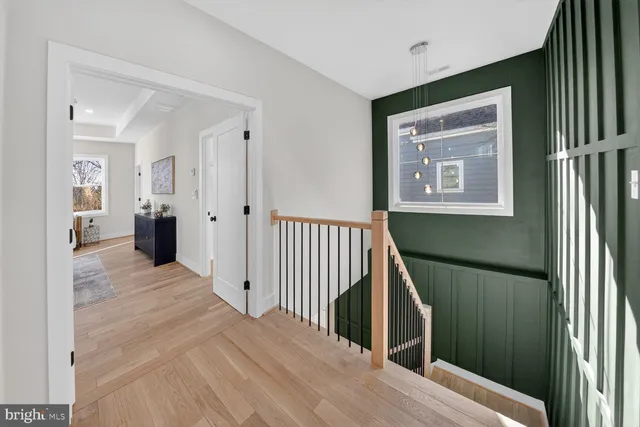a view of a hallway with wooden floor and staircase