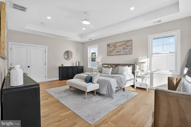a spacious bedroom with a bed and wooden floor