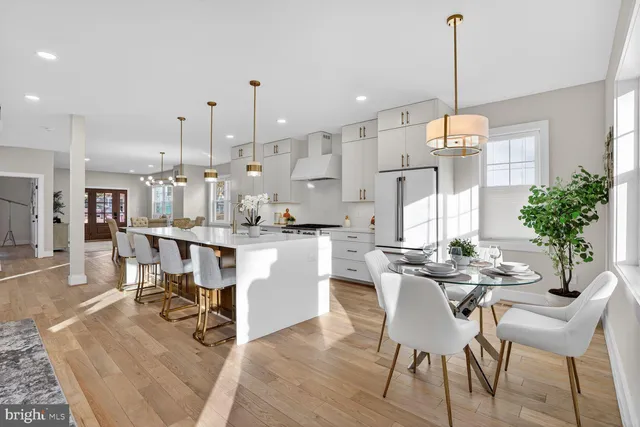 a dining room with stainless steel appliances kitchen island granite countertop a table chairs and a living room view