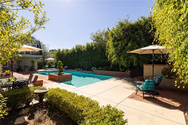 a view of a swimming pool with chairs and plants