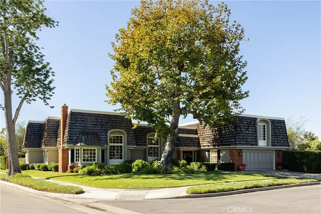 a view of a house with a yard and large tree and plants