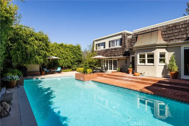 a view of a house with swimming pool and sitting area
