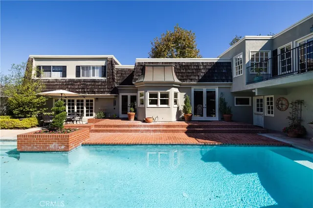 a front view of a house with swimming pool having outdoor seating