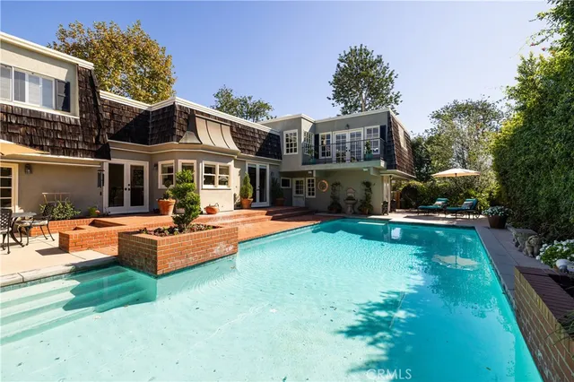 a front view of a house with garden and sitting area