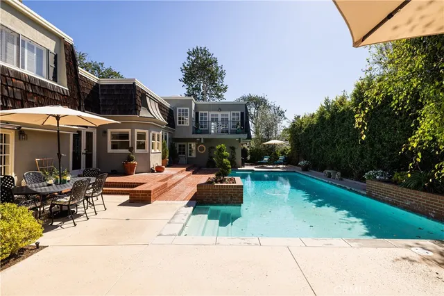 a view of a house with swimming pool and sitting area