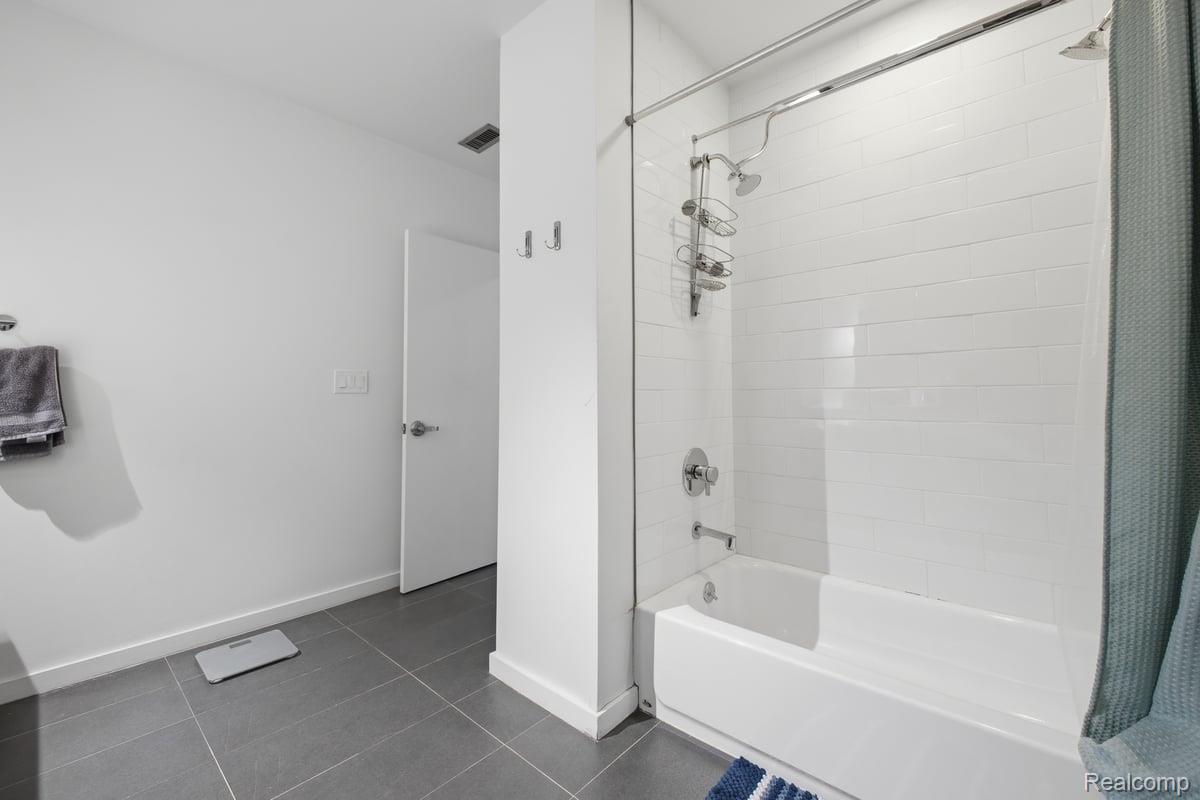 211 East 9 Mile Road, Unit 313 Ferndale, MI 48220 - Photo 18 of 40 Bathroom featuring shower / bath combo and dark tile patterned floors
