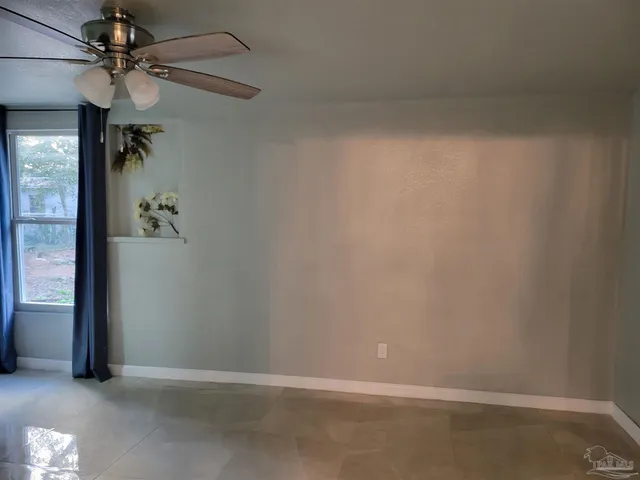 en empty room with windows and fan