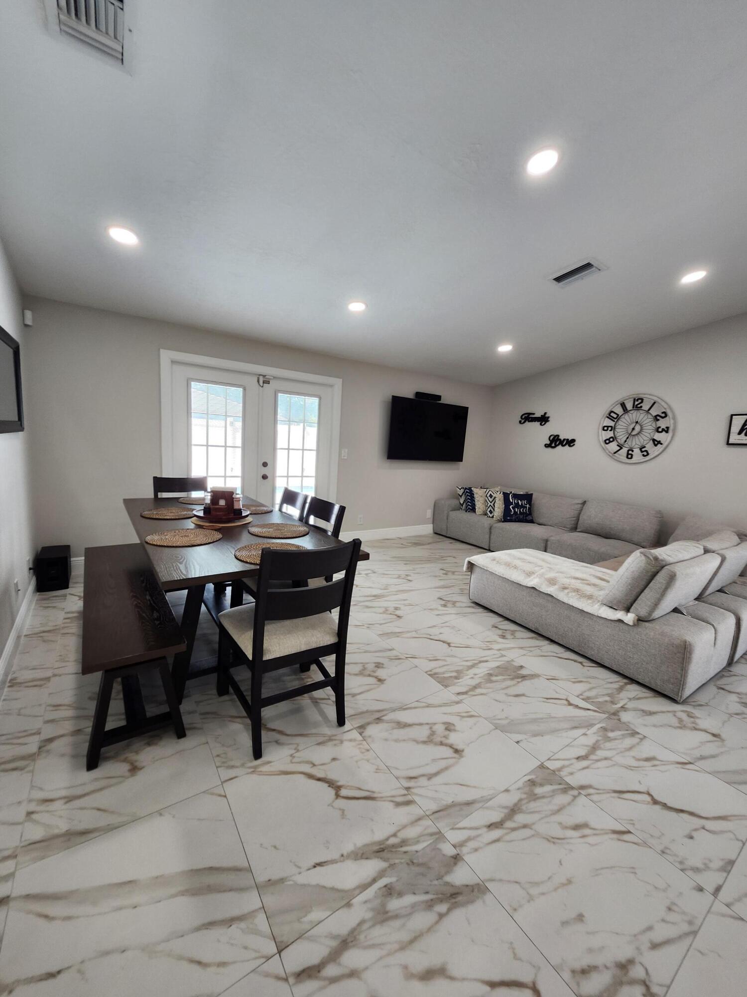 1473 Donwoods Lane Royal Palm Beach, FL 33411 - Photo 13 of 95 a living room with furniture and a dining table with kitchen view