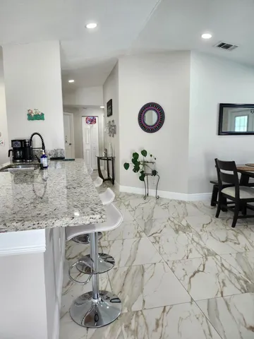a living room with a table a computer and a window