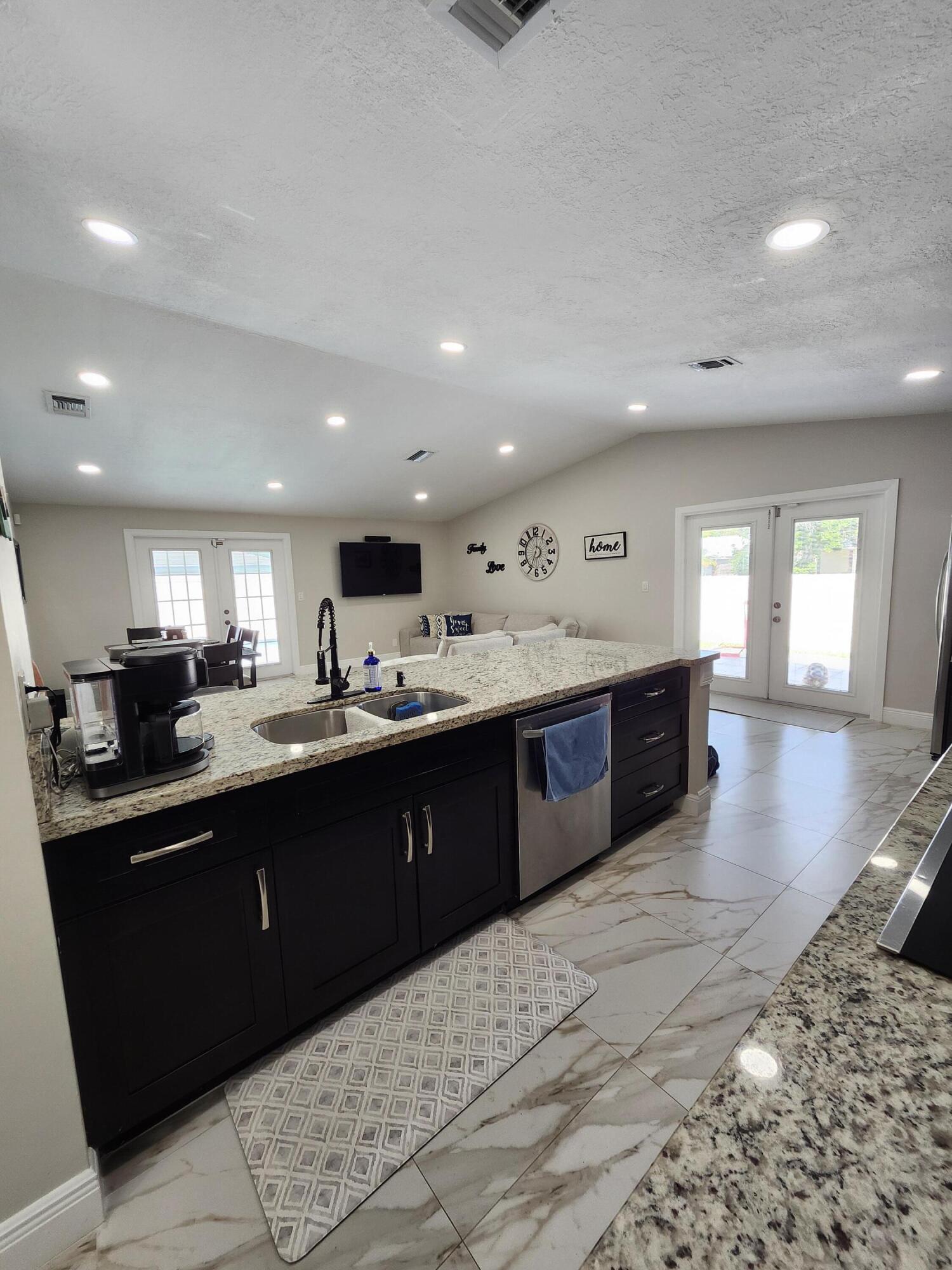 1473 Donwoods Lane Royal Palm Beach, FL 33411 - Photo 17 of 95 a large kitchen with stainless steel appliances granite countertop a large counter top and a stove