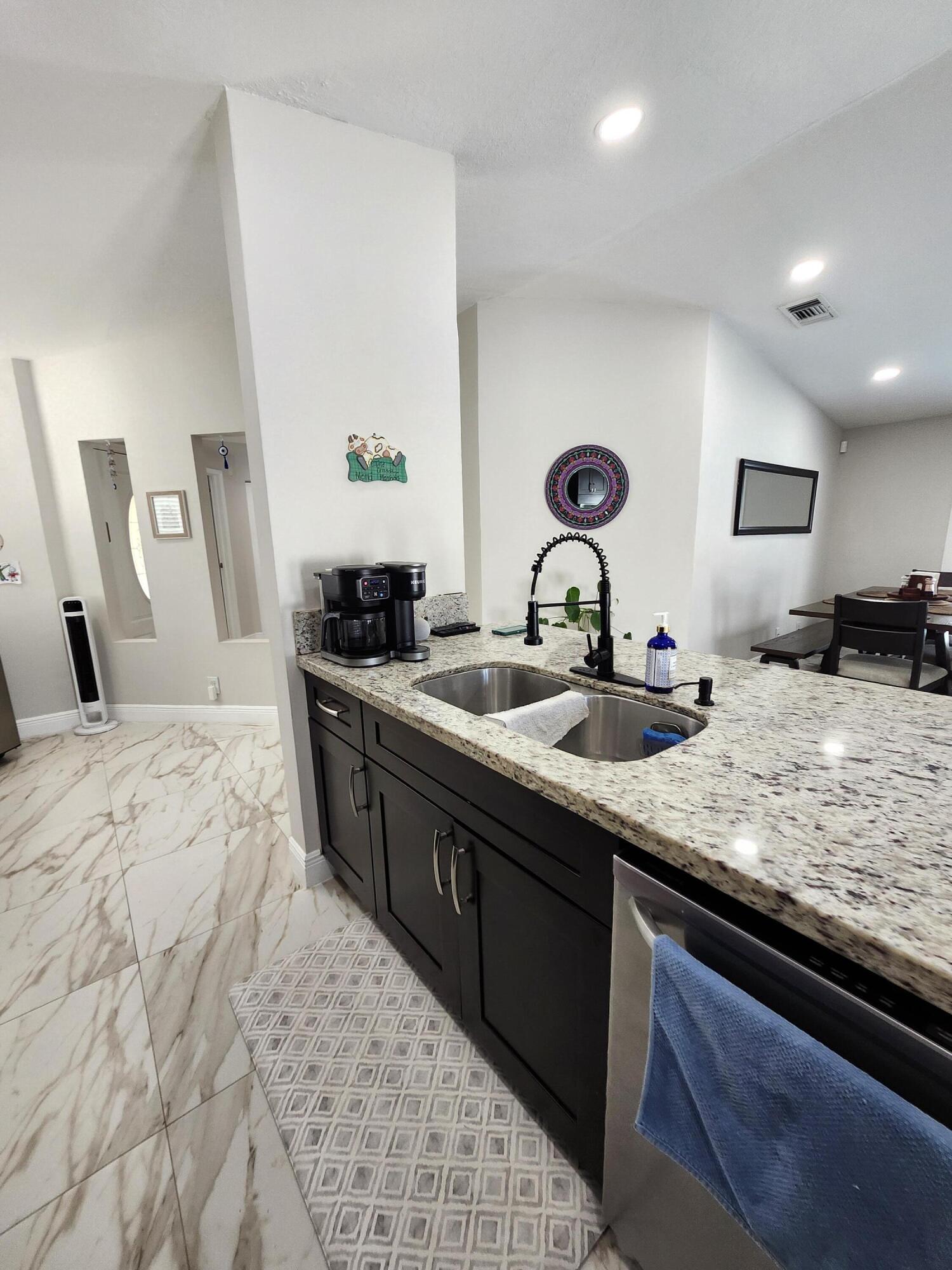 1473 Donwoods Lane Royal Palm Beach, FL 33411 - Photo 23 of 95 a kitchen with stainless steel appliances granite countertop a sink stove and cabinets