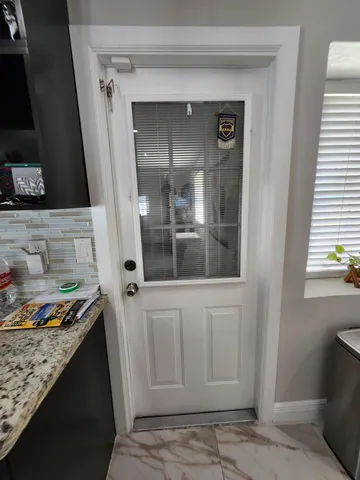 a living room with furniture a flat screen tv and a refrigerator