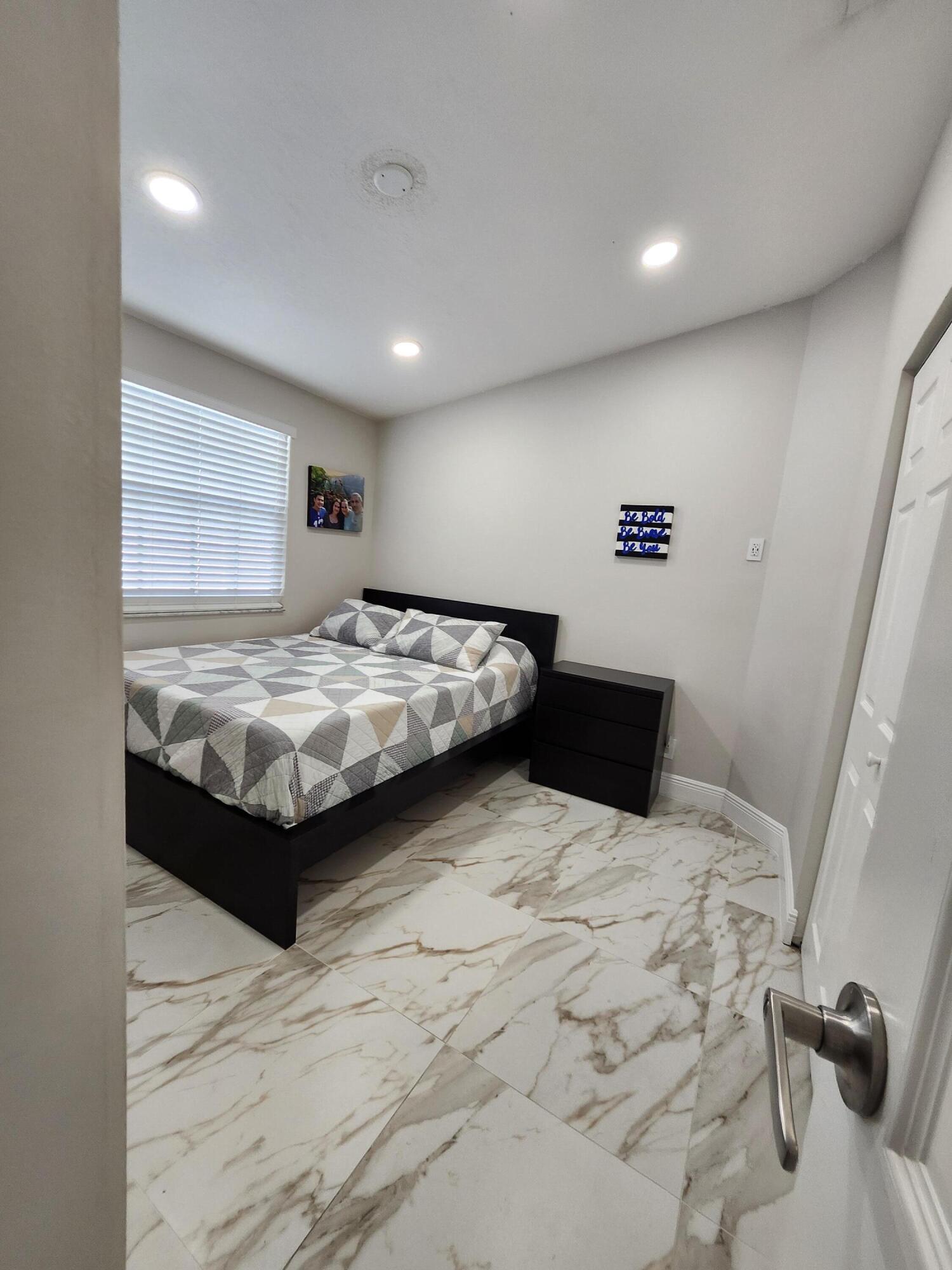 1473 Donwoods Lane Royal Palm Beach, FL 33411 - Photo 53 of 95 a bedroom with a large bed and a flat screen tv