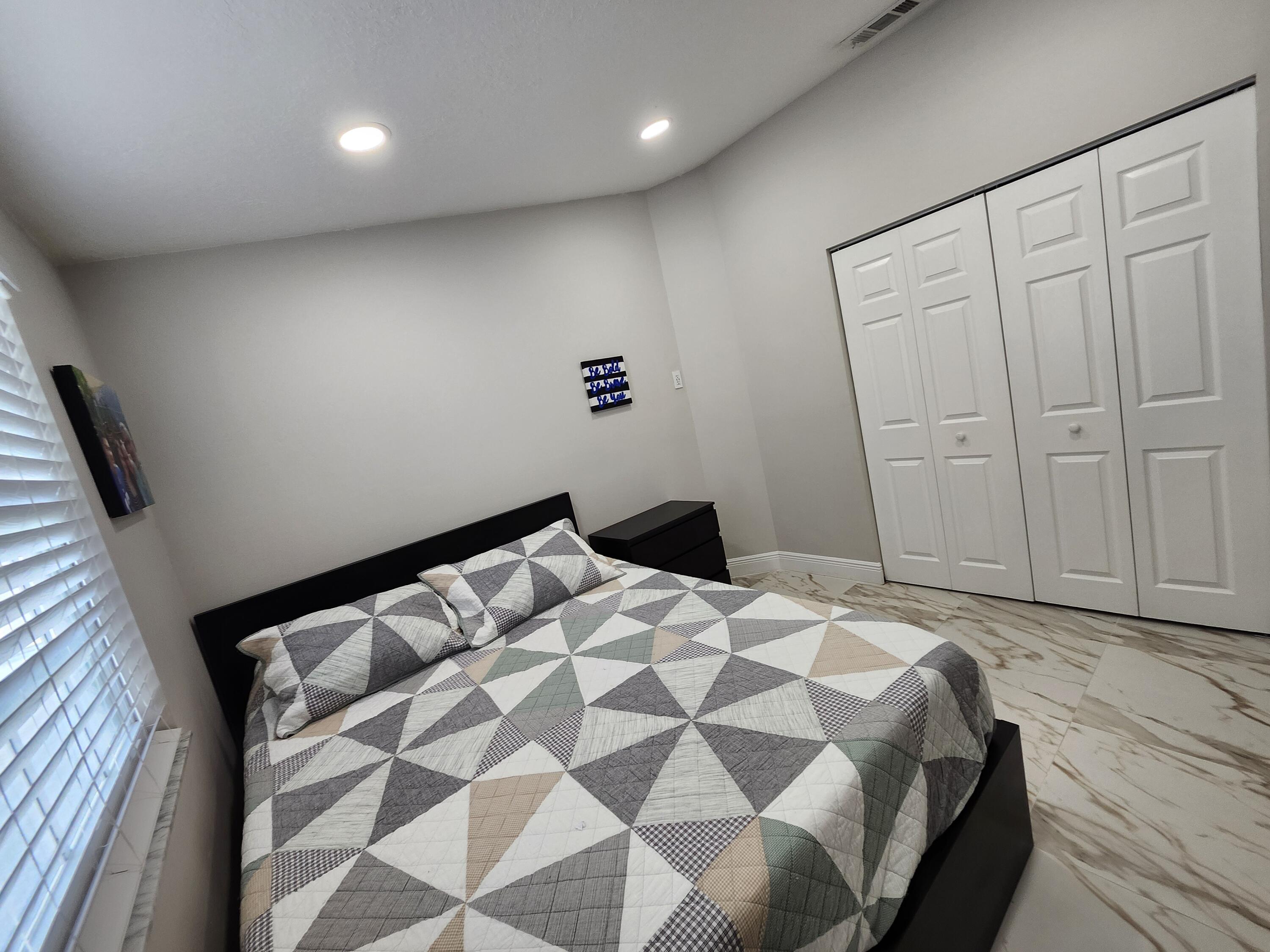 1473 Donwoods Lane Royal Palm Beach, FL 33411 - Photo 54 of 95 a bedroom with a bed and a walk in closet