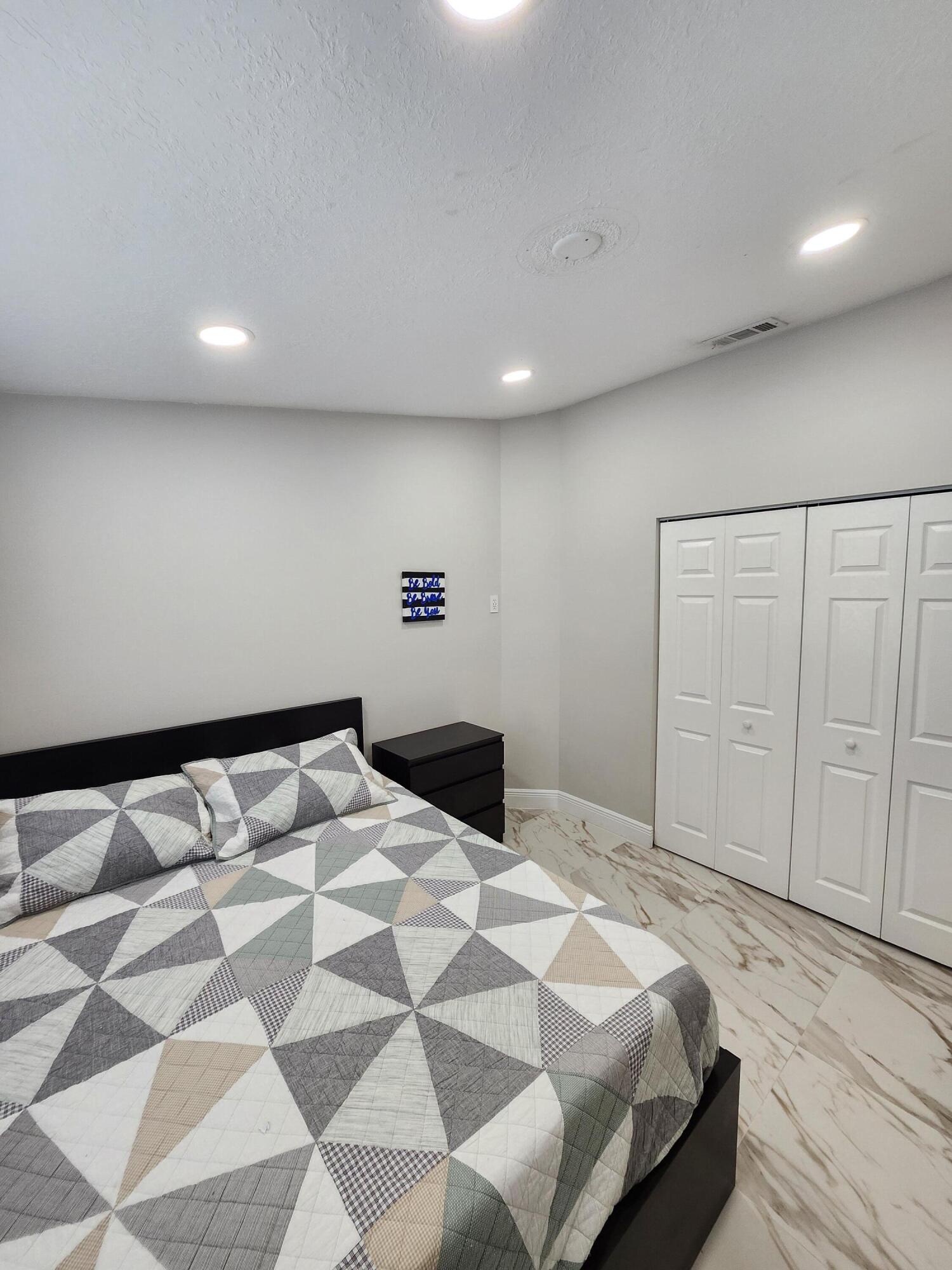 1473 Donwoods Lane Royal Palm Beach, FL 33411 - Photo 55 of 95 a bedroom with a large bed and a walk in closet