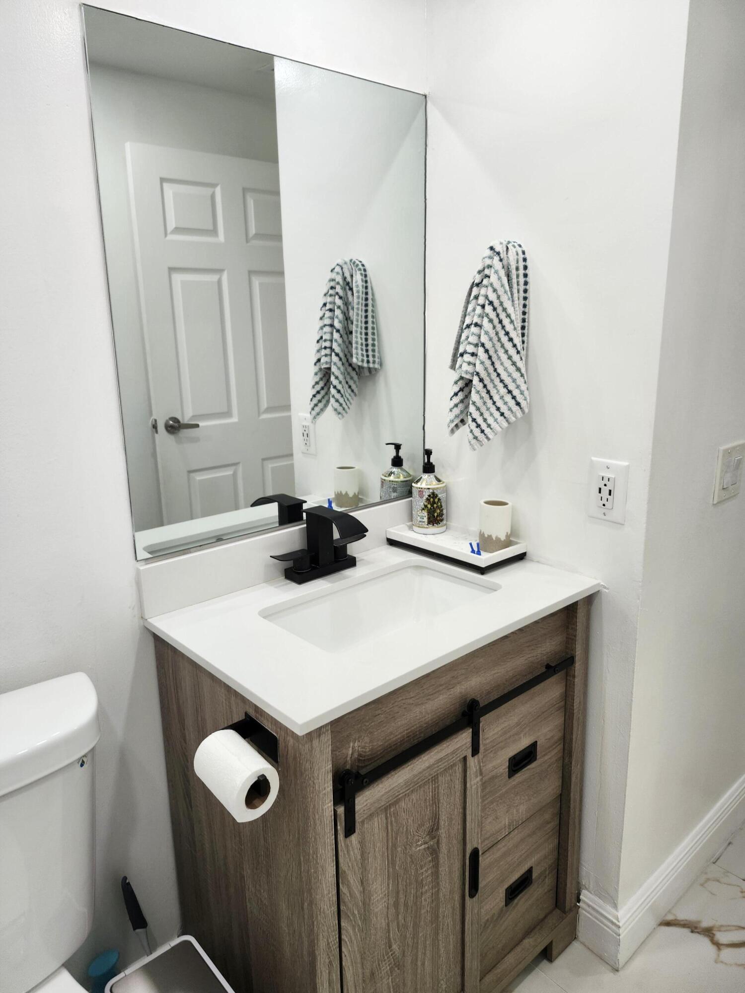 1473 Donwoods Lane Royal Palm Beach, FL 33411 - Photo 64 of 95 a bathroom with a sink a toilet and a mirror