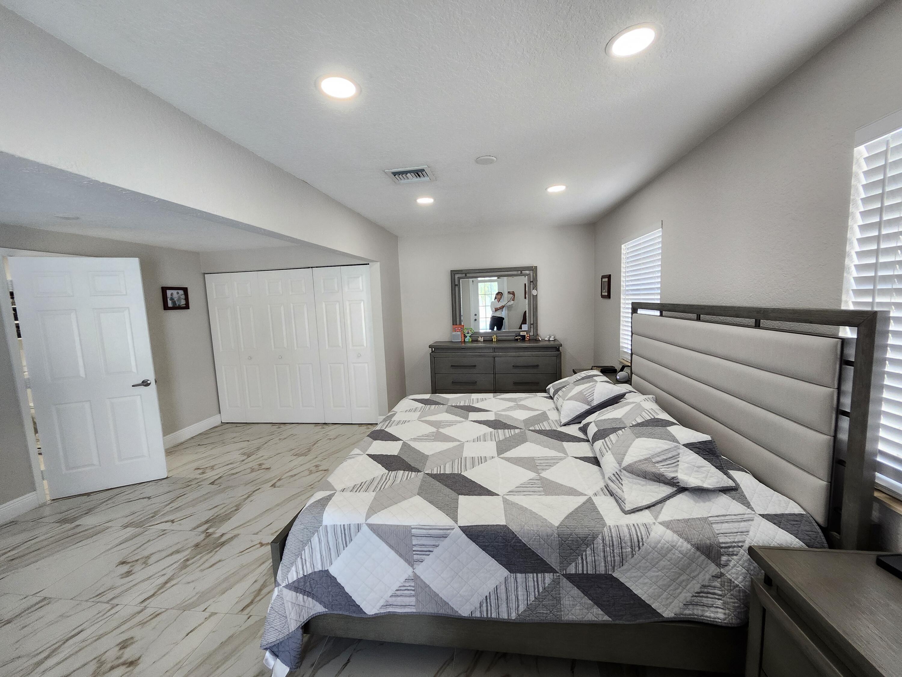 1473 Donwoods Lane Royal Palm Beach, FL 33411 - Photo 68 of 95 a bedroom with a bed and a dresser