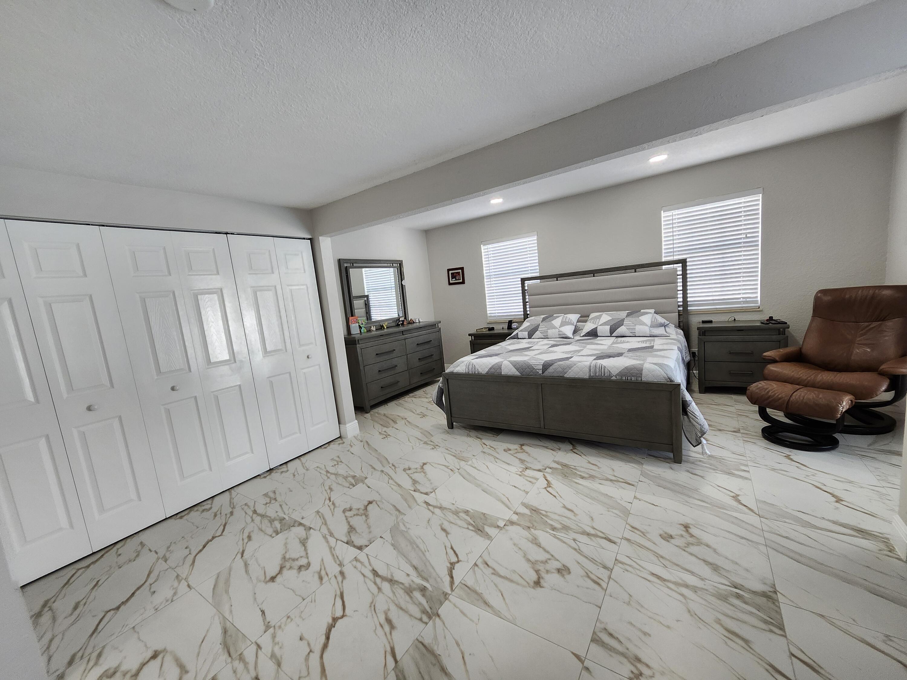 1473 Donwoods Lane Royal Palm Beach, FL 33411 - Photo 71 of 95 a bedroom with a bed a couch and dresser