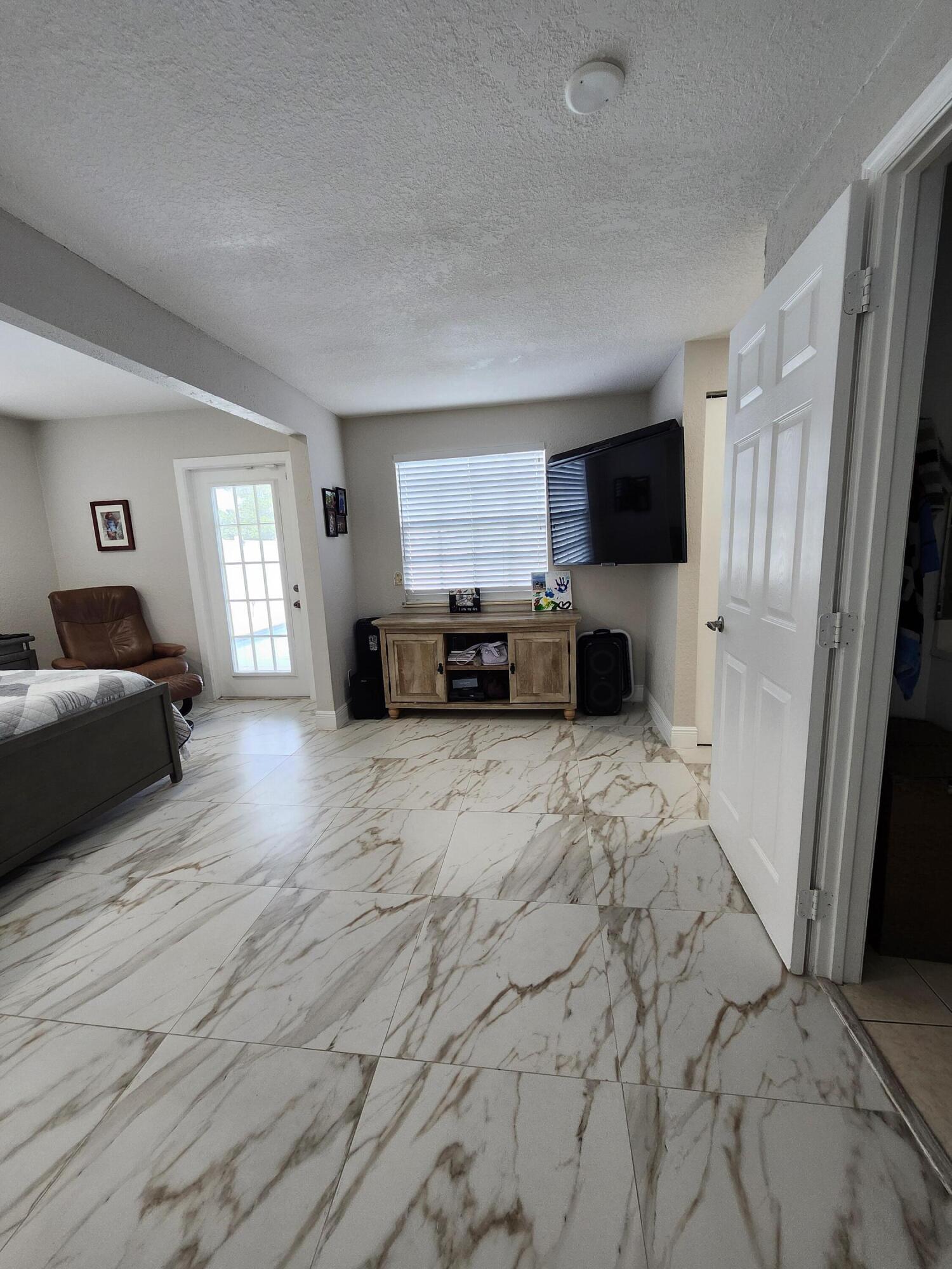 1473 Donwoods Lane Royal Palm Beach, FL 33411 - Photo 83 of 95 a living room with furniture a flat screen tv and a refrigerator