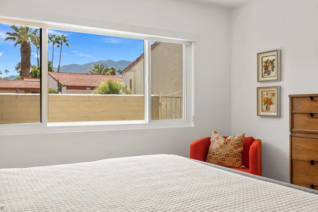 a bedroom with a bed and a painting on the wall