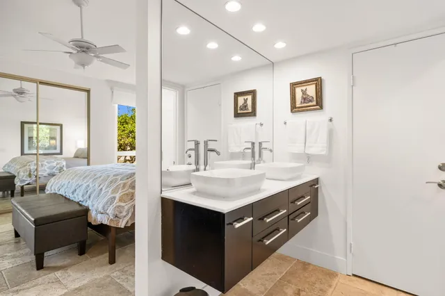 a spacious bedroom with a bed a couch and a chandelier