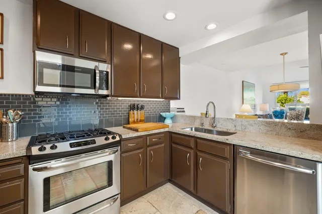 a kitchen with stainless steel appliances a stove sink and cabinets