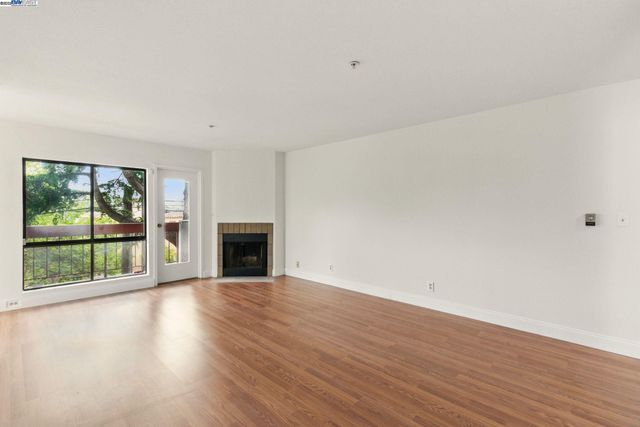 a view of a room with wooden floor and fireplace
