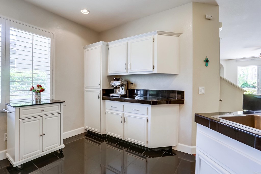 6094 Citracado Circle Carlsbad, CA 92009 - Photo 11 of 28 a kitchen with granite countertop white cabinets and white appliances