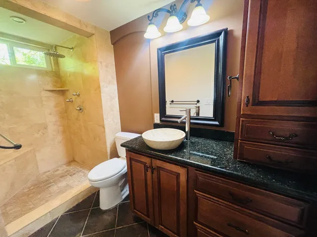 a bathroom with a granite countertop sink and a mirror